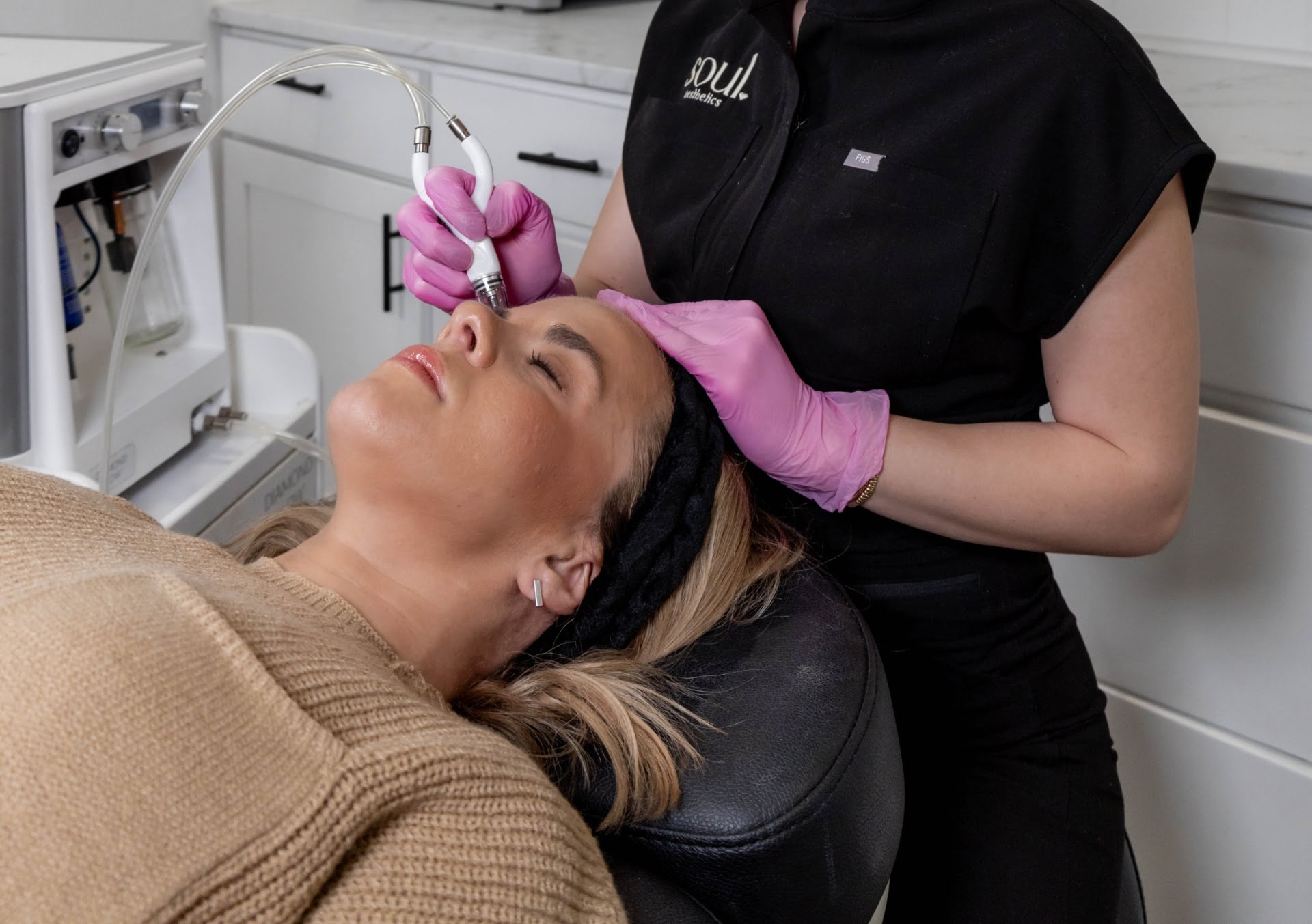 Cosmetologist in gloved hands rate quality of silver medical beauty mask on woman`s face with luminous elastic skin. Concept of spa , body care and hydration. Diamond Glow Facials | Soul Aesthetics in Tulsa, OK